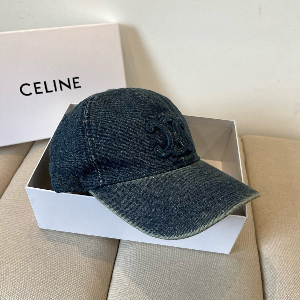 Washed blue denim cap with tonal emblem and gold buckle